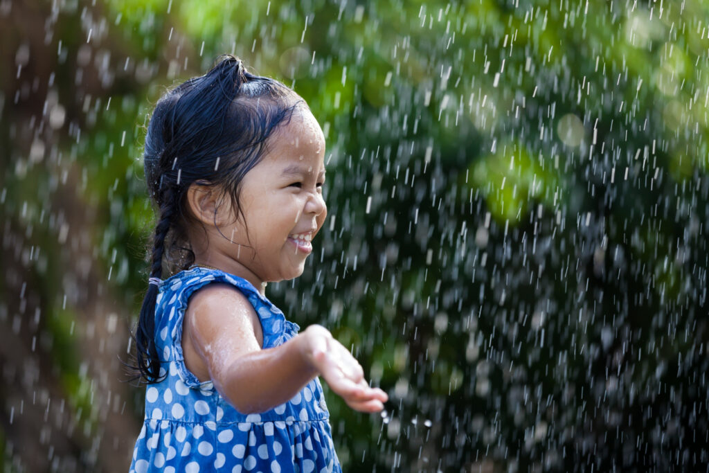 Anak kecil wanita senang main hujan hujanan